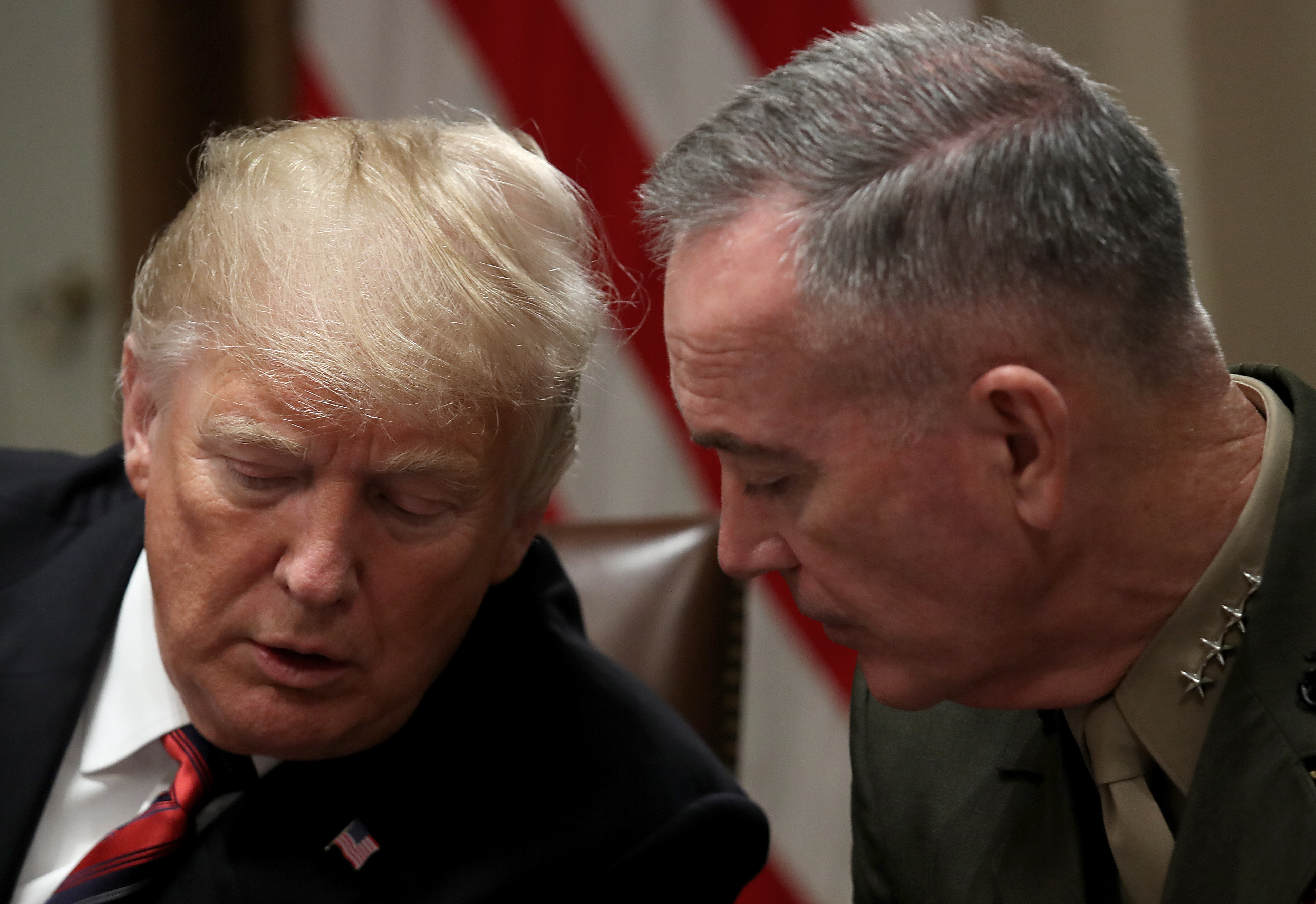 President Donald Trump confers with Chairman of the Joint Chiefs of Staff Joseph Dunford during a meeting with military leaders in the Cabinet Room on October 23, 2018 in Washington, DC. CREDIT: Win McNamee/Getty Images.