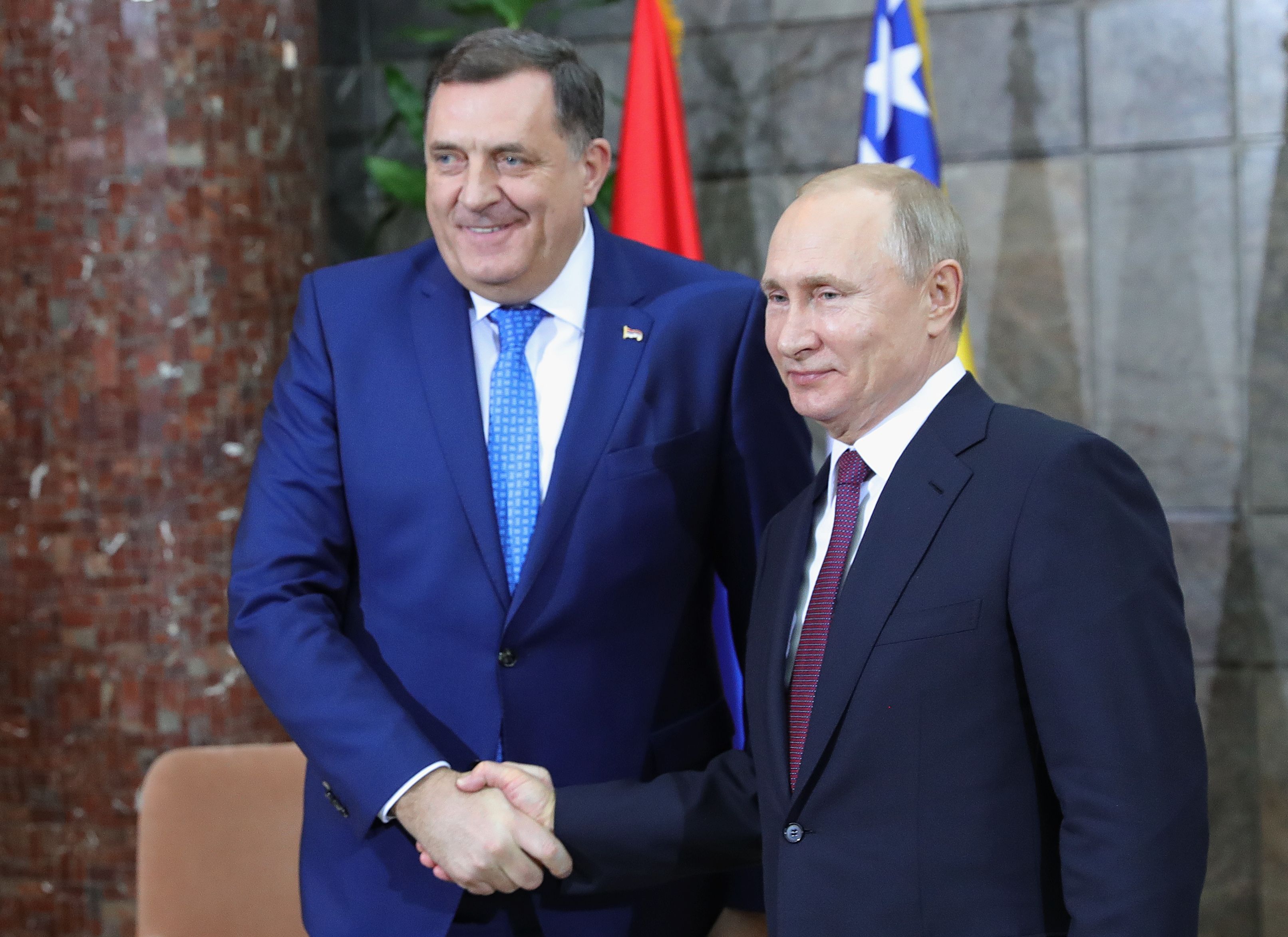 Bosnia's Milorad Dodik (left), who is sanctioned by the U.S., has been close with Russian President Vladimir Putin (right) for years. CREDIT: MIKHAIL KLIMENTYEV / GETTY