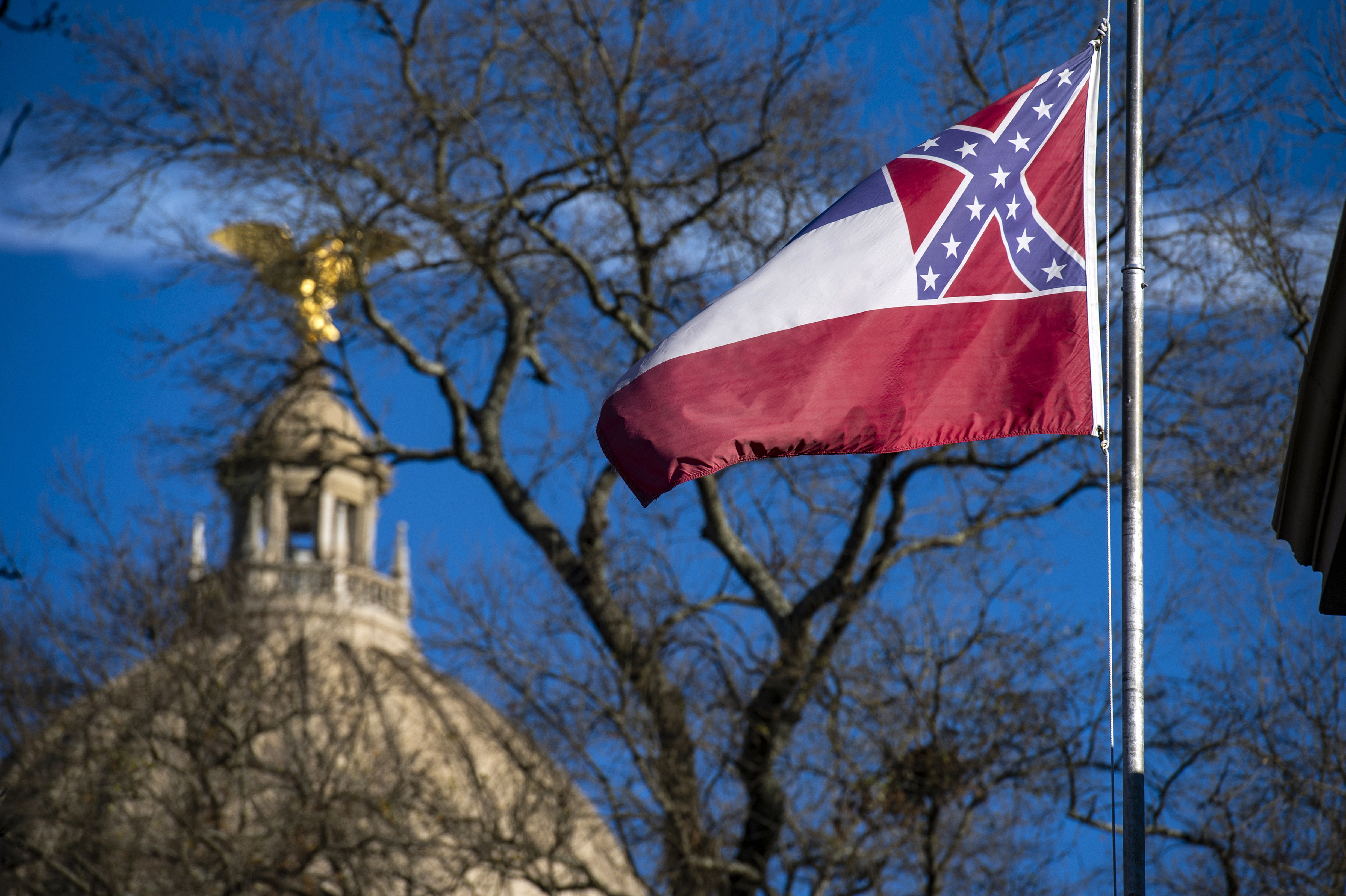 Jackson, MS - JANUARY 10: The Mississippi State Capitol dome is visible in the distance as the flag of the state of Mississippi flies nearby in Jackson, MS on January 10, 2019. (Photo by Brandon Dill for The Washington Post via Getty Images)
