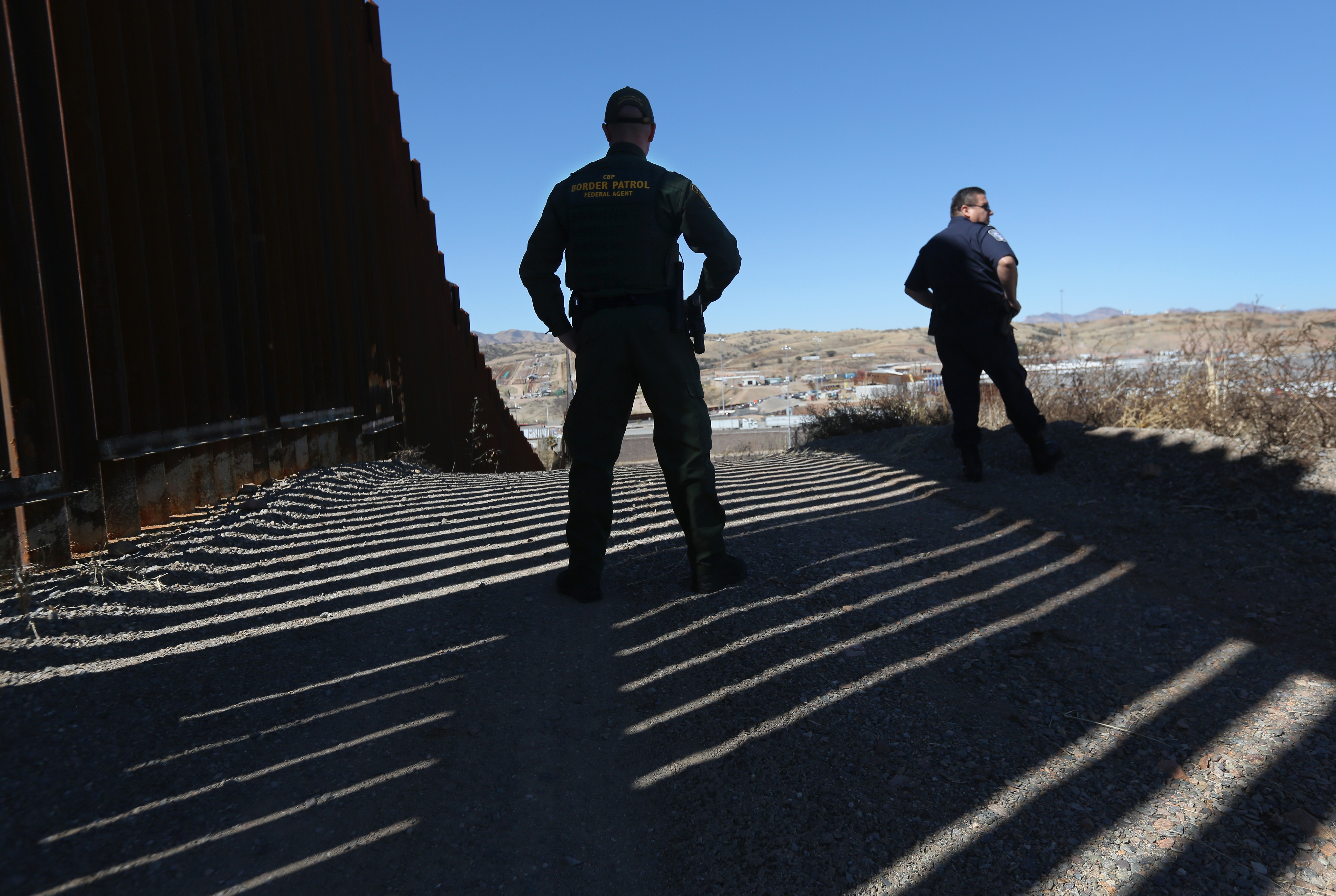NOGALES, AZ - FEBRUARY 26: U.S. Customs and Border Protection agents stand at the U.S.-Mexico border fence on February 26, 2013 in Nogales, Arizona. Various federal agencies are tasked with securing the border from drug smugglers and illegal immigration in the Tucson sector of Nogales, the busiest port of entry in Arizona. (Photo by John Moore/Getty Images)