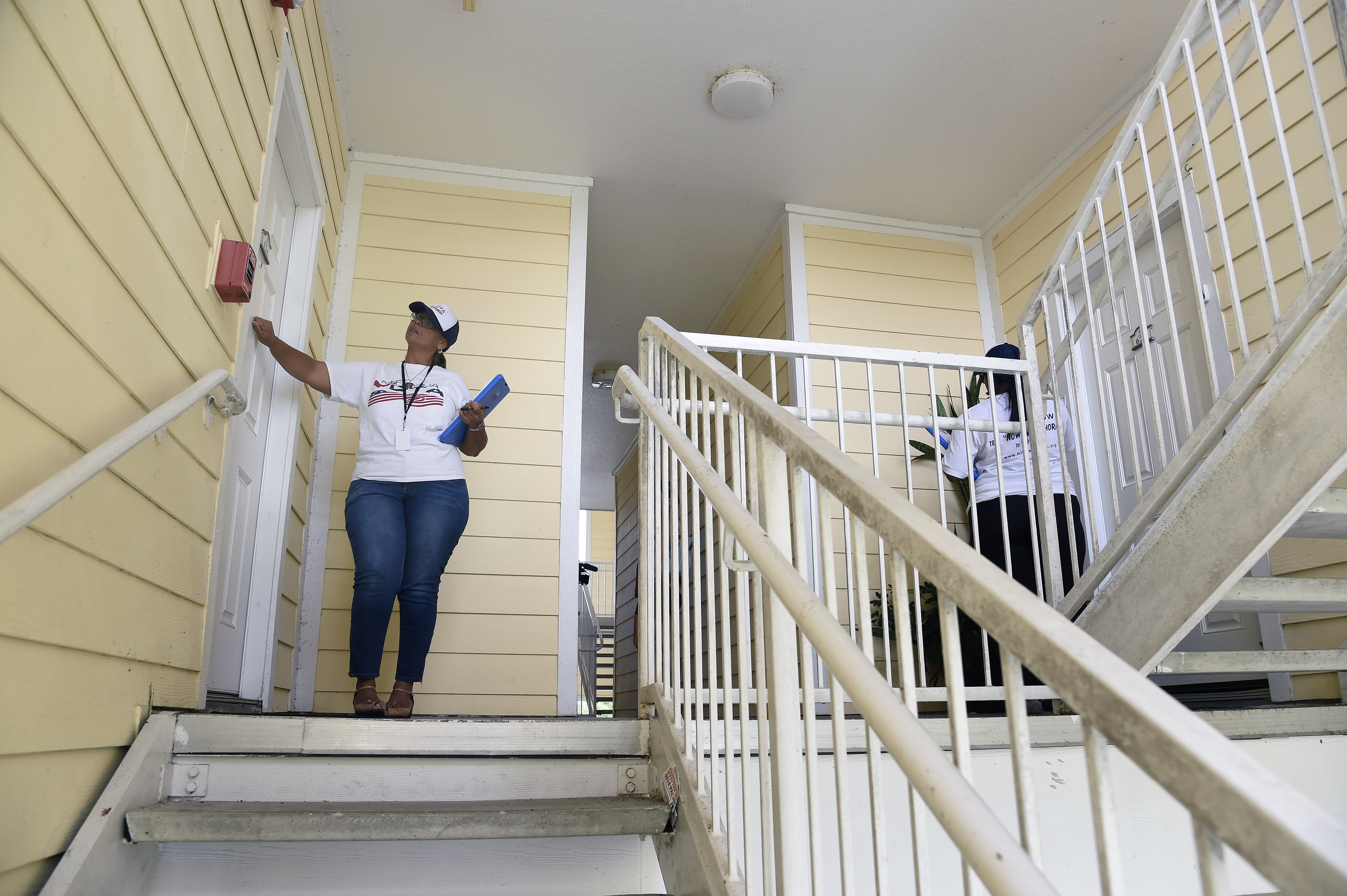 "Mi Famila Vota" (My Family Votes) representatives knock on doors as they canvas a neighborhood to register people to vote in Orlando, Florida on October 3, 2016.
CREDIT: RHONA WISE/AFP/Getty Images