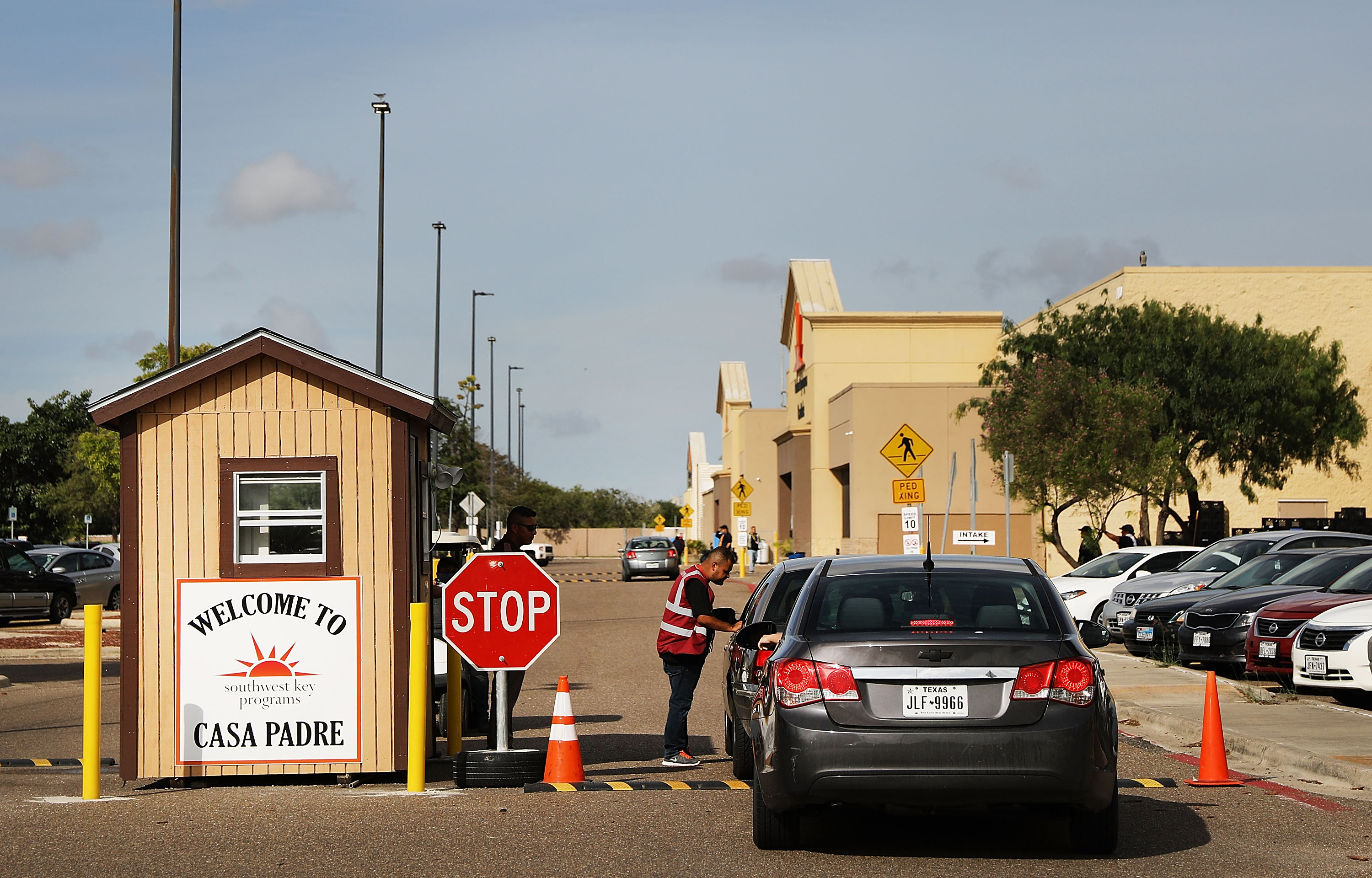 A security guard checks cars at the entrance to Casa Padre, a former Walmart which is now a center for unaccompanied immigrant children on June 24, 2018 in Brownsville, Texas. Photo by Spencer Platt/Getty Images)