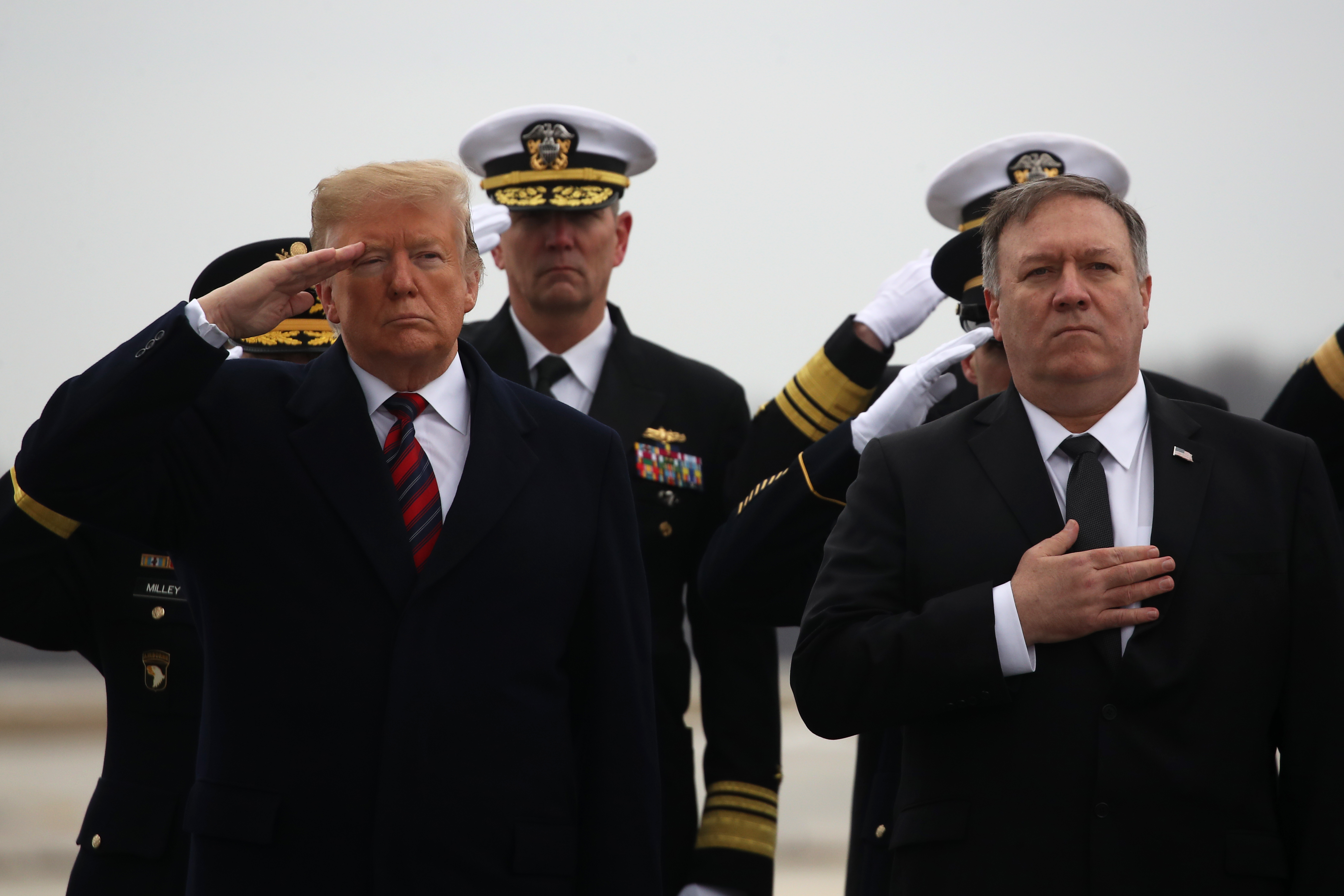 President Donald Trump salutes while joined by Secretary of State Mike Pompeo during a dignified transfer at Dover Air Force Base, January 19, 2019 in Dover, Delaware. (Photo by Mark Wilson/Getty Images)
