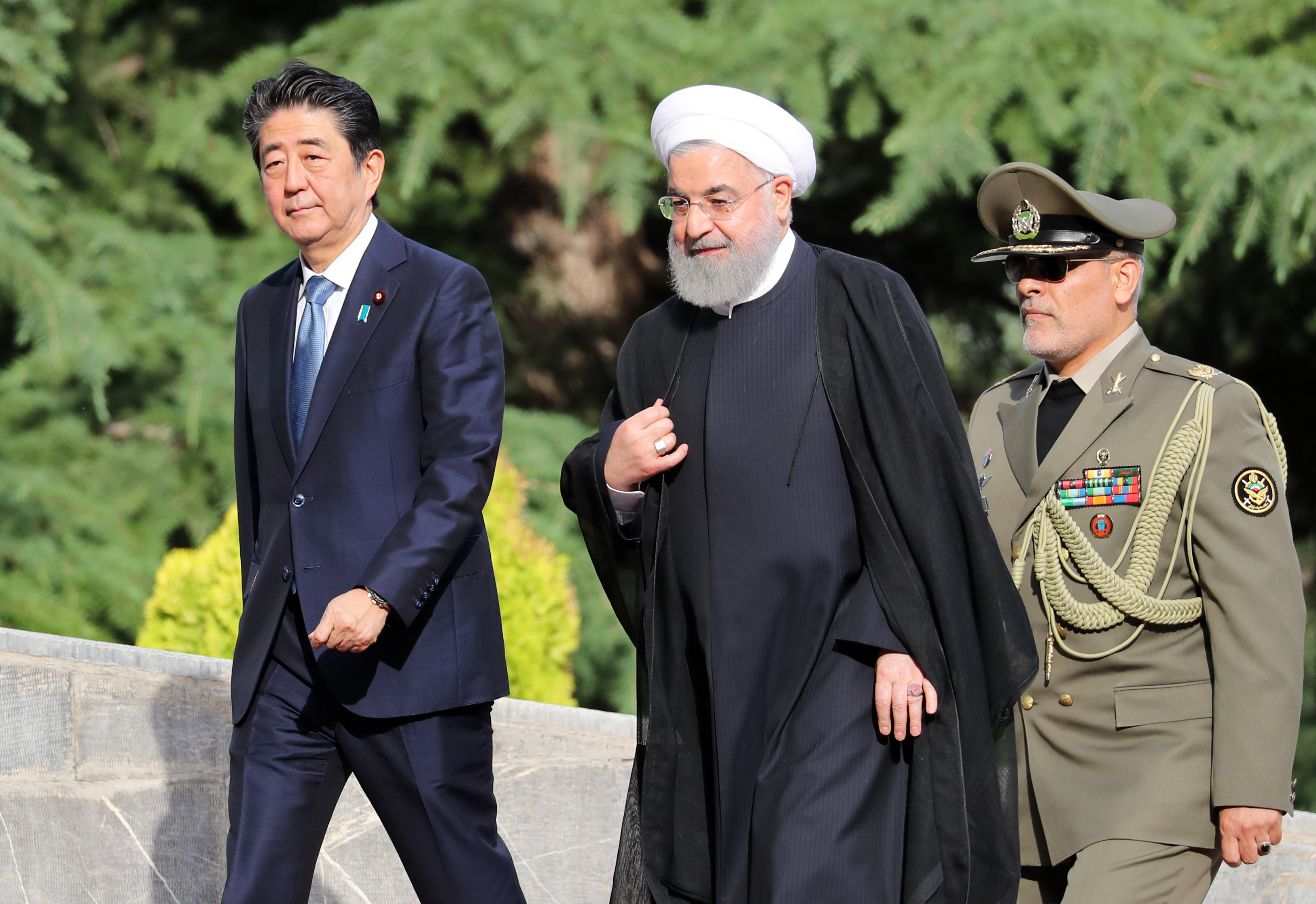 Iranian President Hassan Rouhani accompanies the Japanese Prime Minister Shinzo Abe, during a welcoming ceremony in the Iranian capital Tehran on June 12, 2019. CREDIT: Stringer/AFP/Getty Images.