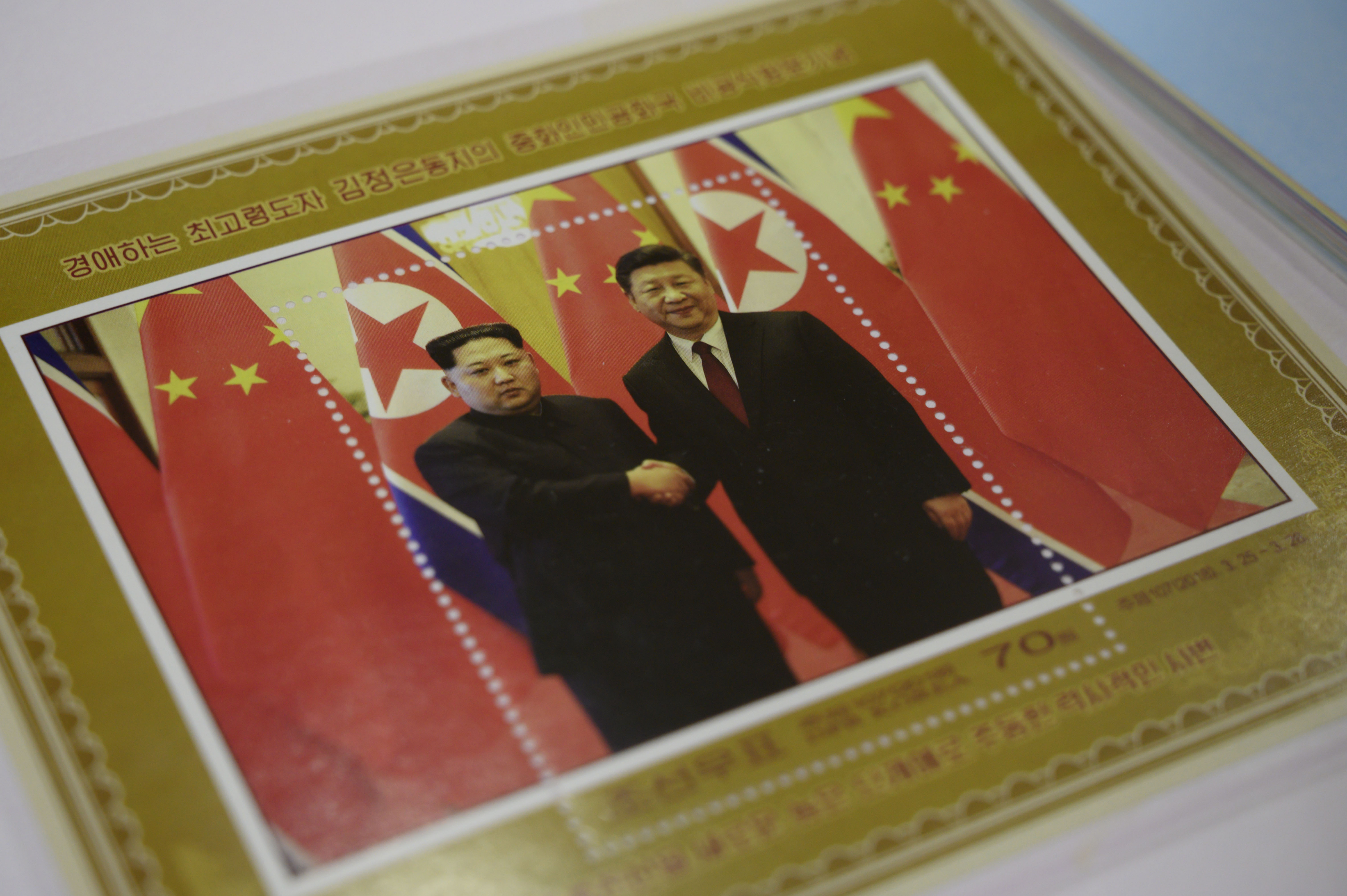 A commemorative stamp featuring North Korean leader Kim Jong-un meeting with China's leader Xi Jinping is pictured at a shop in Pyongyang on June 18, 2019. - Xi Jinping will make the first trip to North Korea by a Chinese president in 14 years this week. CREDIT: Ed JONES/AFP/Getty Images.