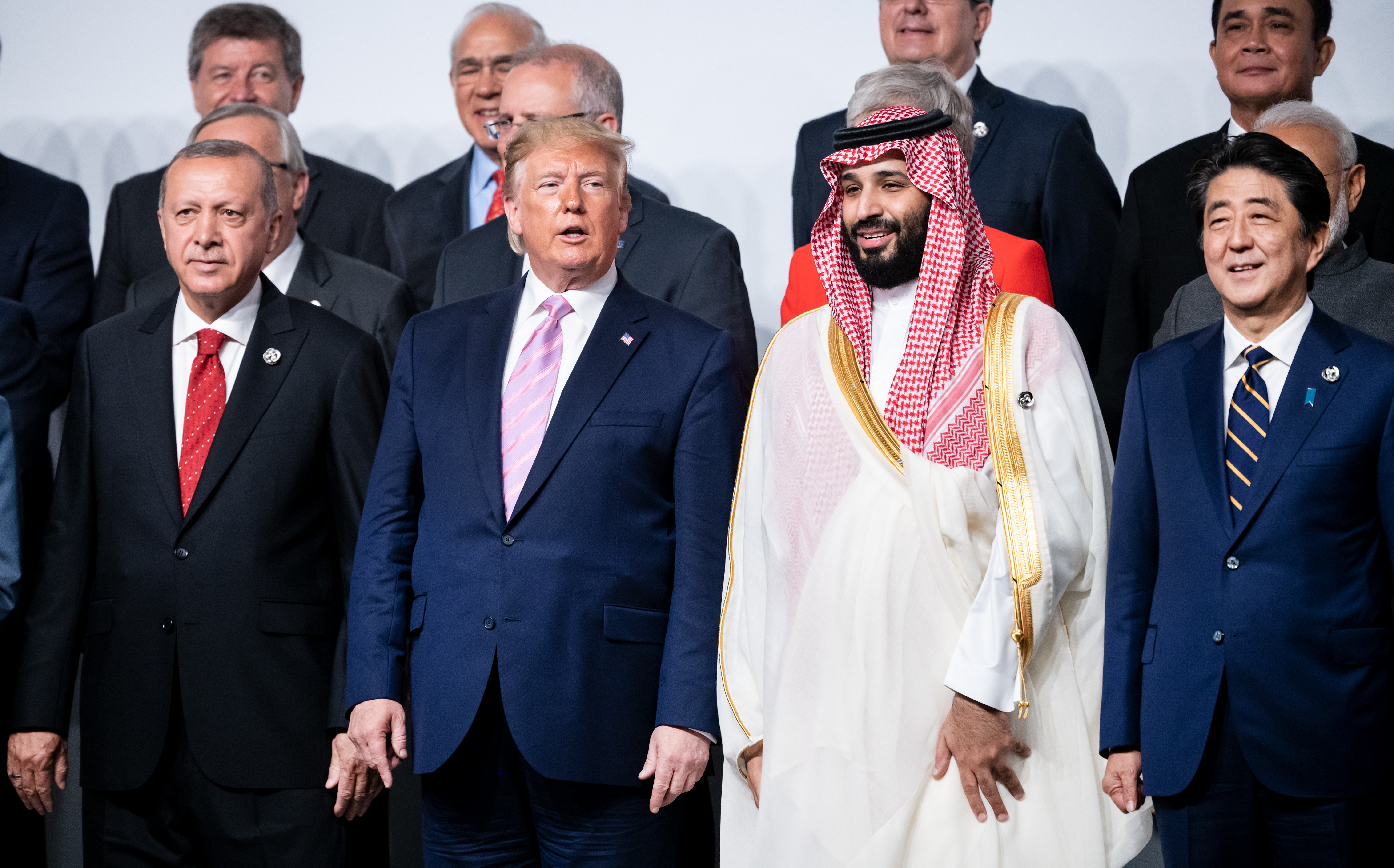 President Donald Trump poses next to Saudi Crown Prince Mohammed bin Salman in the group picture at the start of the G20 summit on Friday, June 28, 2019. CREDIT: Bernd von Jutrczenka/Picture Alliance/Getty Images.