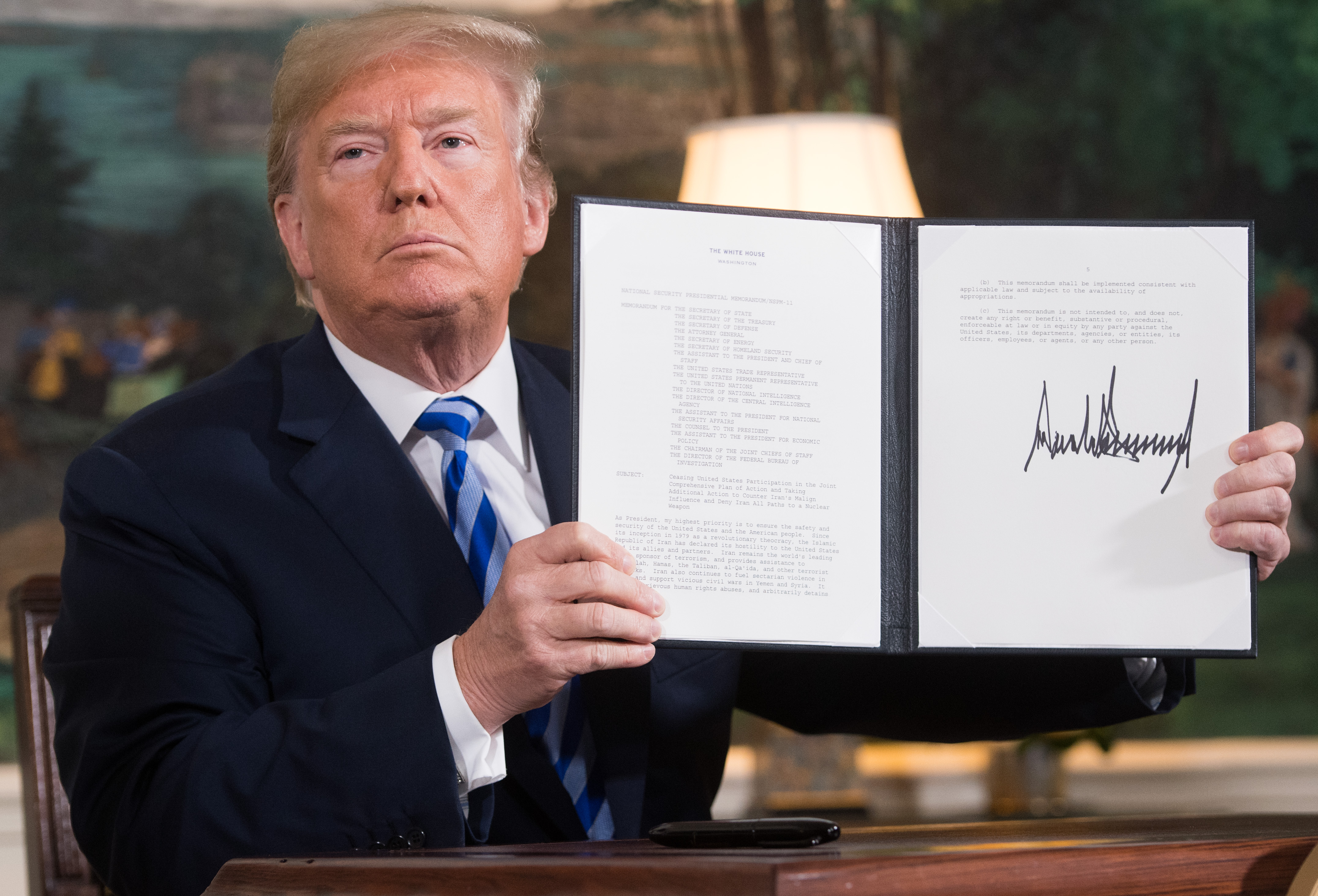 President Donald Trump signs a document reinstating sanctions against Iran after announcing the US withdrawal from the Iran nuclear deal, in the Diplomatic Reception Room at the White House in Washington, DC, on May 8, 2018. He announced new sanctions on Iranian Supreme Leader Ayatollah Ali Khamenei a year late,r on June 24, 2019. (Photo credit: SAUL LOEB/AFP/Getty Images)