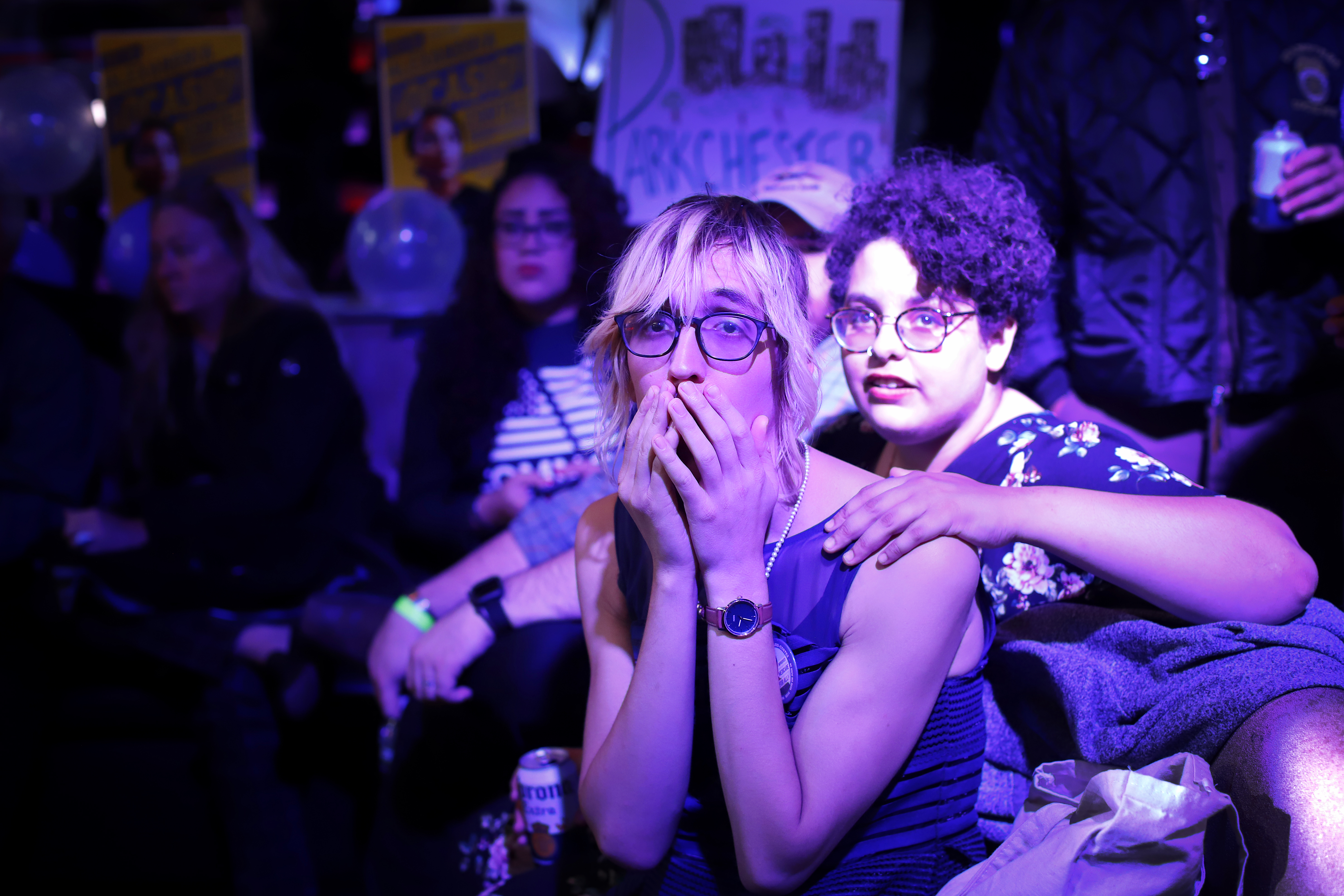 Roxxane Putnam, 26, and Desiree Joy Frias, 25, watch election results come in on the big screen television at La Boom night club in Queens on November 6, 2018 in New York City. Alexandria Ocasio-Cortez celebrated her win in her race against Republican Anthony Pappas at La Boom. CREDIT: Rick Loomis/Getty Images
