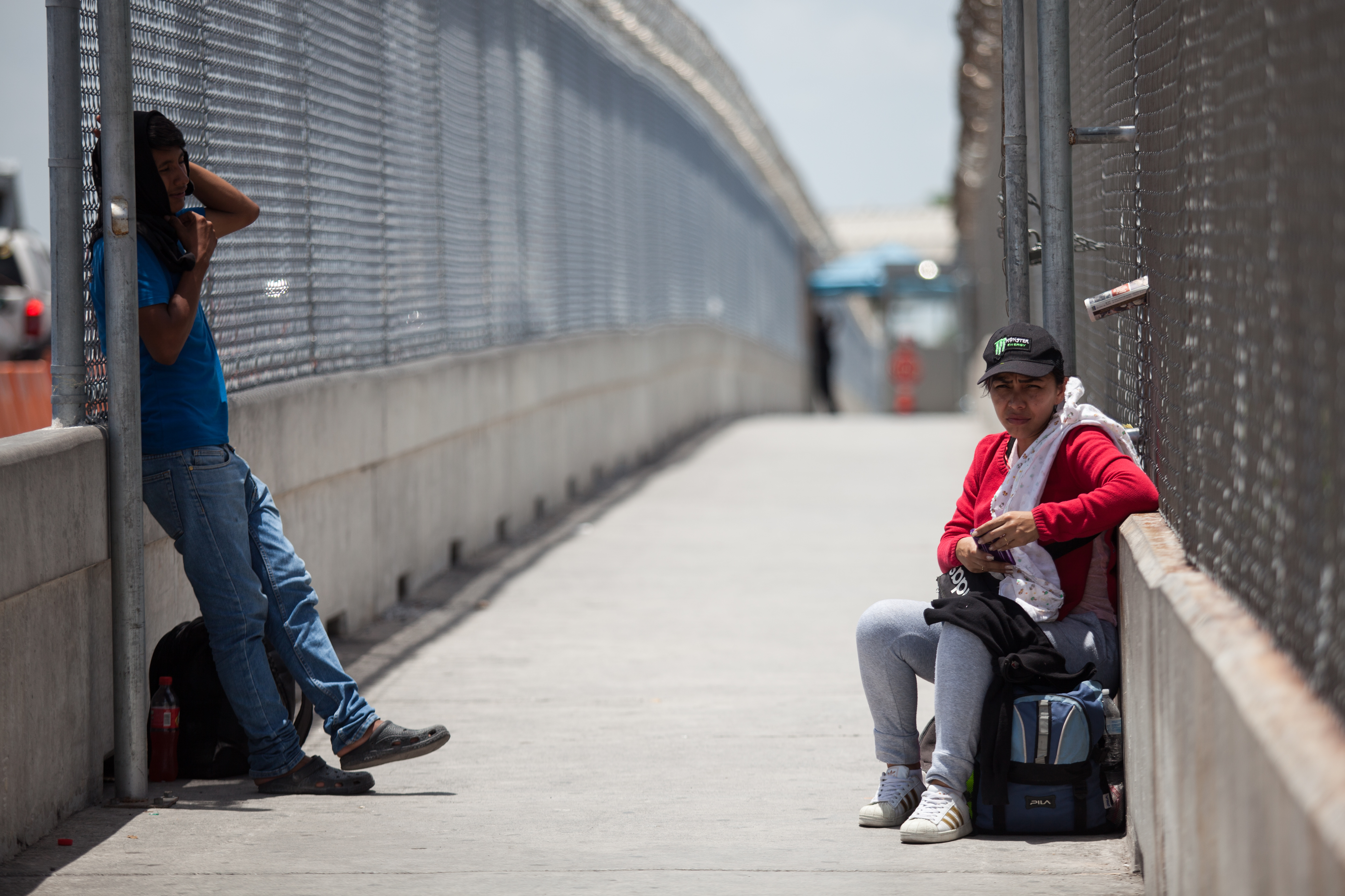 30 June 2019, Mexico, Matamoros: A Guatemalan man and woman wait under the sun on the Puerta Mexico Bridge to be called by the American authorities to initiate the asylum procedure. Hundreds of migrants are waiting near the International Bridge to apply for asylum in the United States. The atmosphere is desperate as many migrants live outdoors in the midst of the high temperatures that prevail in the community on Mexico's northern border. Photo: Carlos Ogaz/dpa (Photo by Carlos Ogaz/picture alliance via Getty Images)