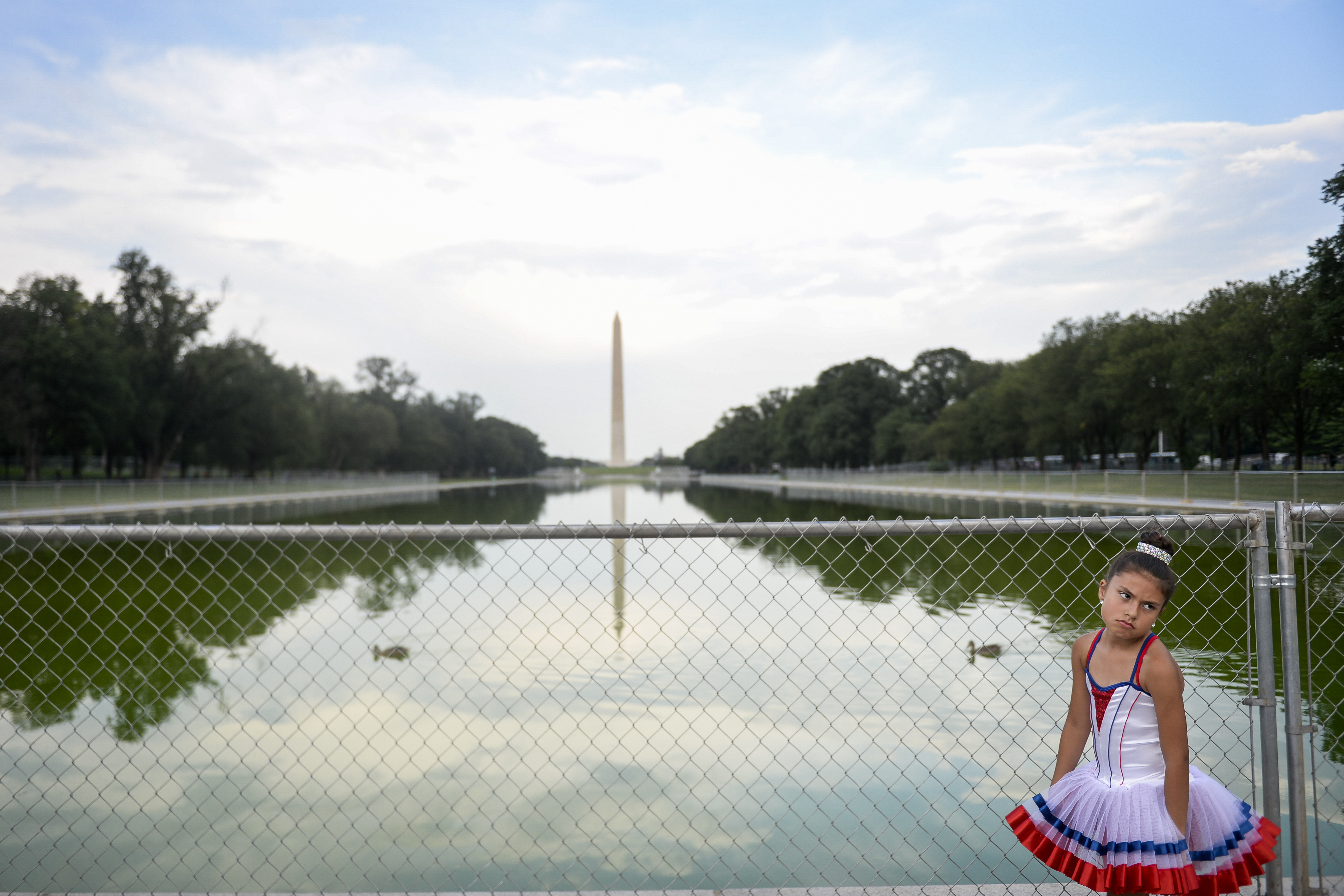 A visitor stands in front of temporary fencing installed along the National Mall as set up continues for President Donald Trump's 'Salute to America' event honoring service branches on Independence Day at the Lincoln Memorial on Tuesday July 2, 2019. CREDIT: Caroline Brahmin/CQ Roll Call.