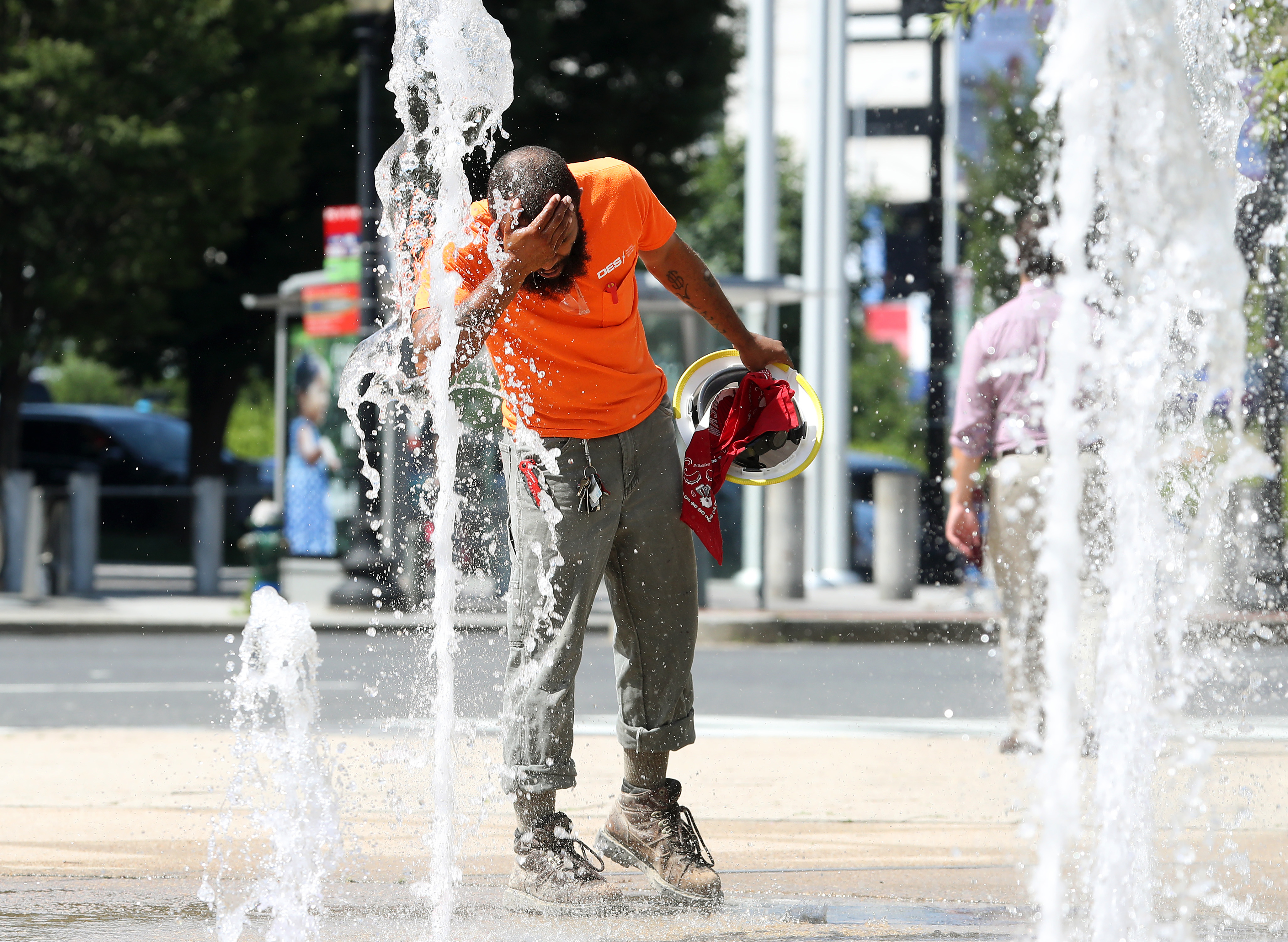 A construction worker stops to cool off in the water fountains at Canal Park, on July 19, 2019, in Washington, DC. An excessive heat warning has been issued for the Washington area as temperatures approach triple digits. CREDIT: Mark Wilson/Getty Images