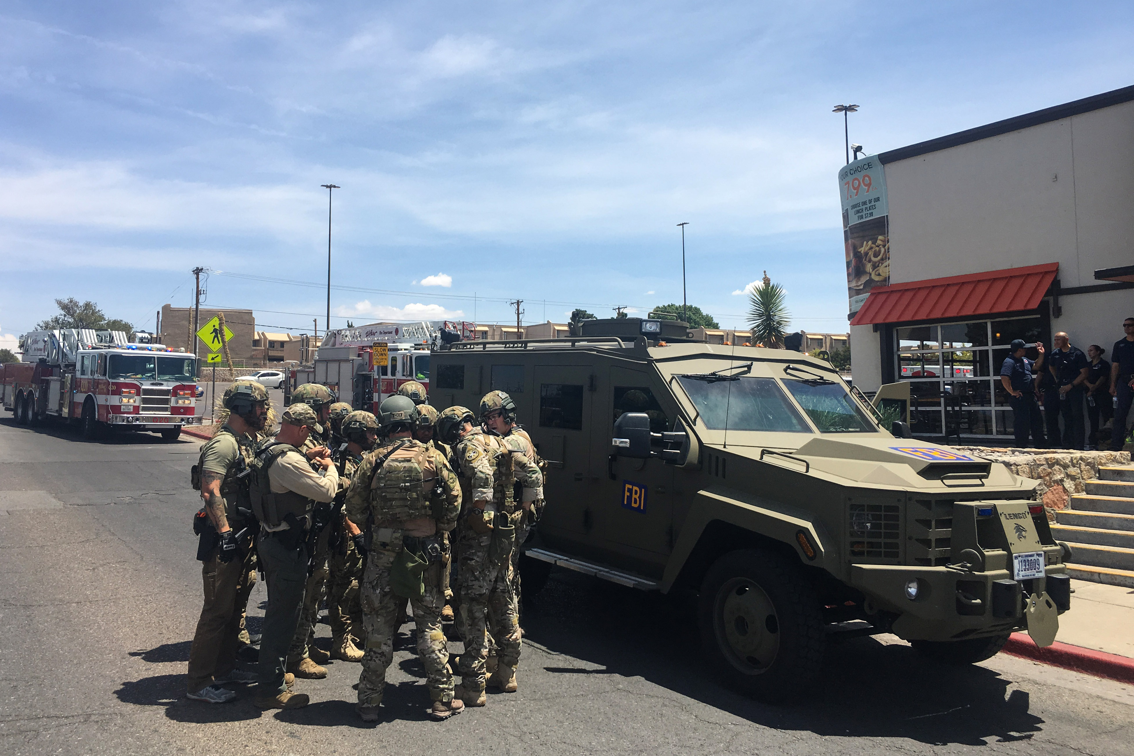 Armed Policemen gather next to an FBI armoured vehicle next to the Cielo Vista Mall as an active shooter situation is going inside the Mall in El Paso on August 03, 2019. (Photo by Joel Angel JUAREZ / AFP)