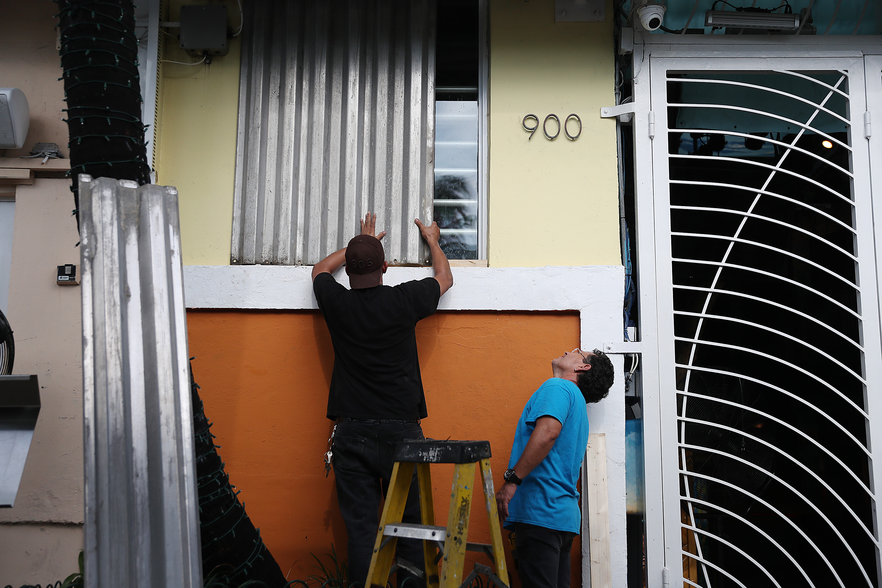 Workers place hurricane shutters over a window as they help prepare a business for the possible arrival of Hurricane Dorian on August 30, 2019 in Miami Beach, United States. CREDIT: Joe Raedle/Getty Images