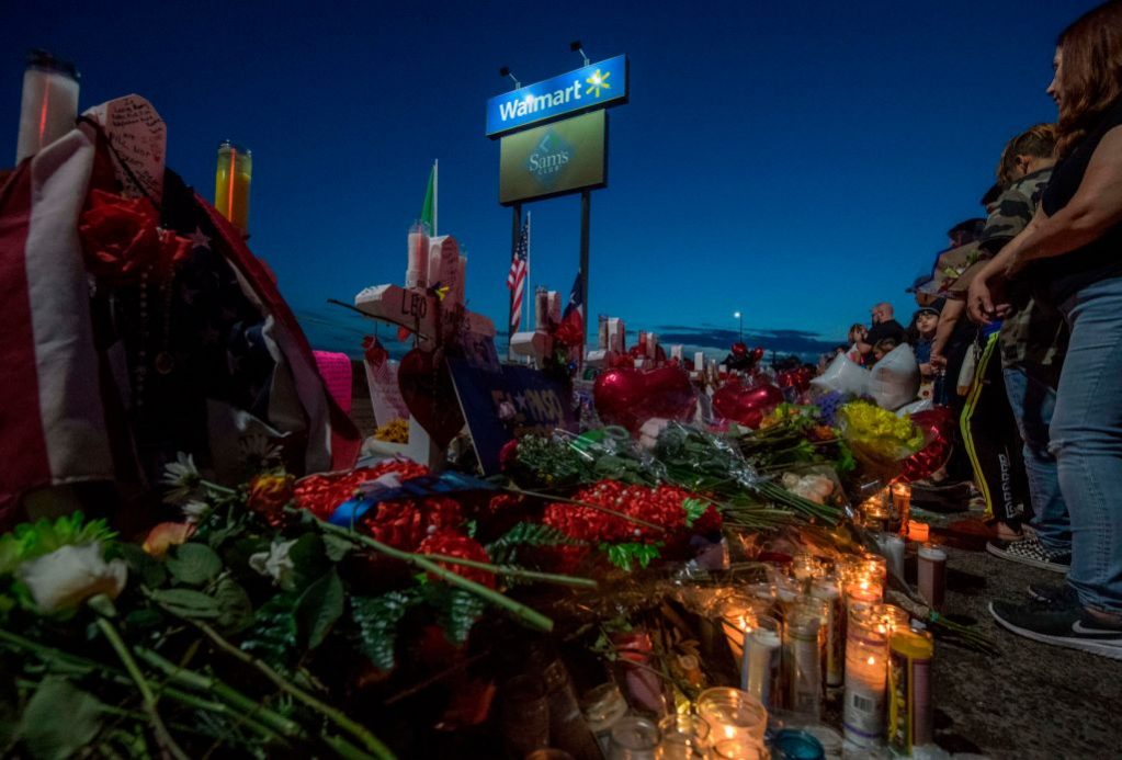 People pay their respects at the makeshift memorial for victims of the shooting that left a total of 22 people dead at the Cielo Vista Mall WalMart in El Paso, Texas, on August 6, 2019. The company announced Tuesday it will scale back its gun and ammo sales.